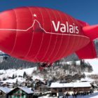 A Hot Air Airship Flying above the Valley Covered in Snow